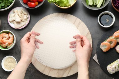 Koyu gri masada nefis börek yapan bir kadın.