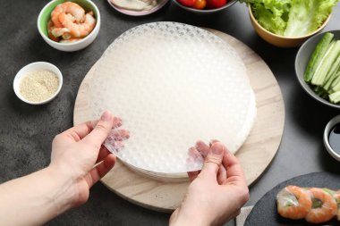 Koyu gri masada nefis börek yapan bir kadın.