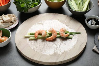 Pilav kağıtları ve koyu gri masa üzerindeki farklı malzemeler, yakın plan.