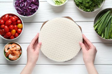 Beyaz ahşap masada nefis börek yapan bir kadın.