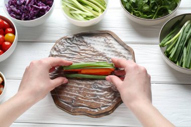 Beyaz ahşap masada nefis börek yapan bir kadın.