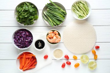 Pirinç kağıt çarşaflar ve beyaz ahşap masa üzerindeki farklı malzemeler.