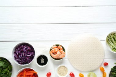 Pilav kâğıdı çarşafları ve beyaz ahşap masa üzerindeki farklı malzemeler. Metin için boşluk