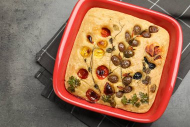 Gri masadaki fırında sebzeli ve zeytinli enfes Focaccia. Metin için boşluk