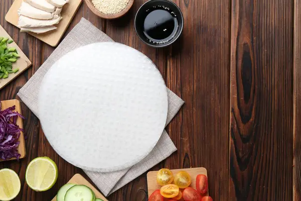 Yenebilir pirinç kağıtları ve ahşap masa üzerindeki malzemeler düz. Metin için boşluk