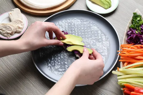 Gri ahşap masada nefis börek yapan kadın, yakın plan.