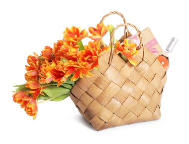 Güzel laleler, şarap şişesi ve hasır çantanın içindeki hediye kutusu beyazlar içinde izole edilmiş.