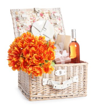 Güzel laleler, şarap şişesi, hediye kutuları ve piknik sepetindeki yemek takımı.