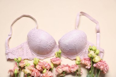 Pembe dantelli sütyen ve bej arka planda Eustoma çiçekleri.