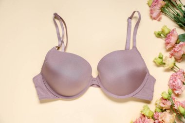 Bej arka planda güzel sutyen ve Eustoma çiçekleri, düz yatıyordu.