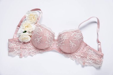 Beyaz arka planda pembe dantel sütyen ve Eustoma çiçekleri.