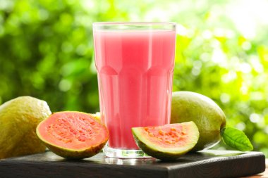 Guava suyunu tazeliyorum ve ahşap masada taze meyveler, yakın plan.