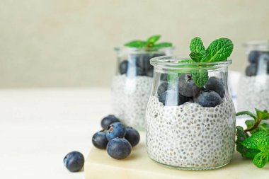 Yaban mersinli Chia pudingi ve ışıklı masada nane şekeri, yakın plan. Metin için boşluk