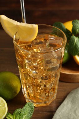 Buzlu çayı limon dilimi, kireç ve nane şekeri ile ahşap masada tazeliyorum. Yakın plan.