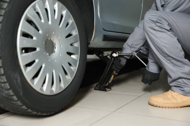 Makas kriko ile kaldırılan araba. Servis istasyonunda otomatik mekanik değiştirme tekerleği, kapat