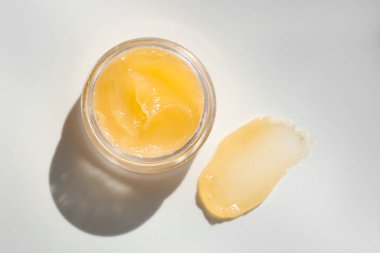 Beyaz arka planda kavanoz ve dudak kremi örneği, üst görünüm