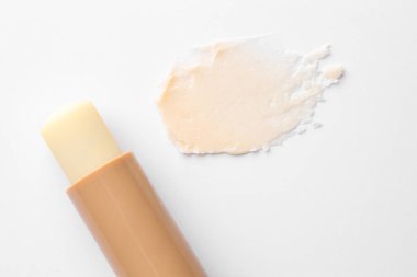 Dudak kremi ve örnek beyaz arka planda, üst görünümde.