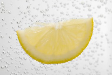 Soda water with lemon slice as background, closeup
