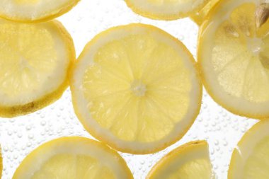 Arka planda limon dilimleri olan soda, yakın plan.