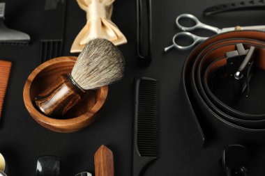 Siyah masada birçok farklı berber aleti var, yakın plan.