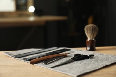 Berber dükkanında, açık ahşap masanın üzerinde birçok farklı berber aleti var.