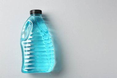 Gri arka planda plastik şişede antifriz, üst manzara. Metin için boşluk