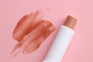 Pembe arka planda nemlendirici dudak kremi ve ruj.