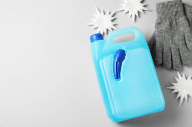 Antifriz, eldivenler ve açık gri arka planda kış dekoru. Metin için boşluk