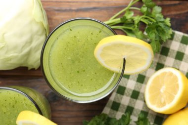 Sağlıklı maydanoz bardakta, limonda, lahanada, ahşap masada.