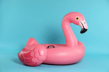 Açık mavi arkaplanda şişirilebilir flamingo şekilli halka