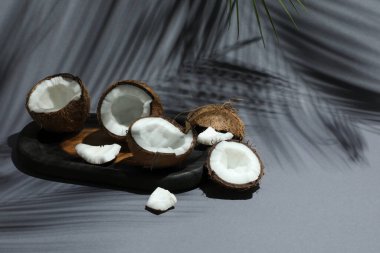 Gri arka planda tropikal palmiyelerin taze hindistan cevizleri ve gölgesi, yakın plan