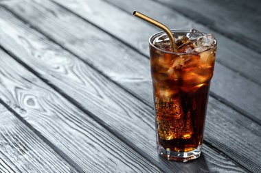 Kolayı buz küpleriyle tazelemek ve gri ahşap masadaki pipetle kaplamak, yakın plan. Metin için boşluk