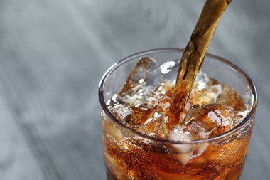 Tazeleyici kolayı bulanık gri arka planda cama döküyorum. Yakın plan. Metin için boşluk