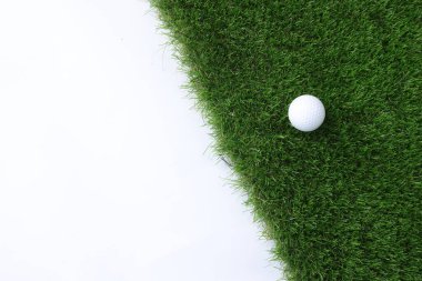 Beyaz arka planda golf topu ve yeşil çimenler, üst manzara. Metin için boşluk