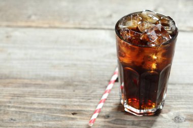 Kola, buzlu cam küplerle tazeleniyor ve ahşap masa üzerinde saman, yakın plan. Metin için boşluk