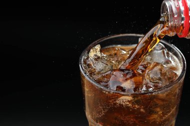 Siyah arka planda ferahlatıcı kolayı cama dökmek, yakın plan. Metin için boşluk