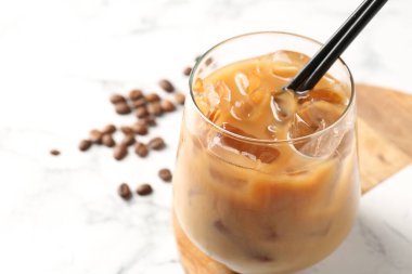 Lezzetli buzlu kahve ve fasulyeler beyaz masada, yakın plan. Metin için boşluk