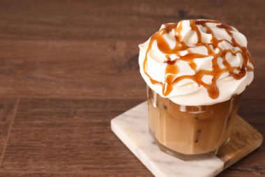 Krem şantili buzlu kahve ve ahşap masada şurup, yakın plan. Metin için boşluk