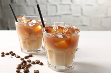 Lezzetli buzlu kahve ve fasulyeler beyaz masada, yakın plan.