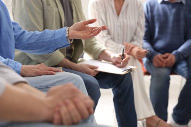 İçeride psikoterapi gören bir grup insan, yakın çekim.