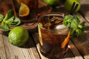 Küba libre kokteylini ahşap masada nane şekeri ile tazeliyorum.