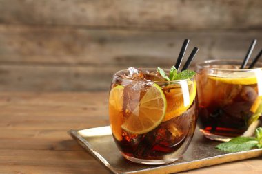 Küba libre kokteylini ahşap masada nane şekeriyle tazeliyorum. Metin için boşluk