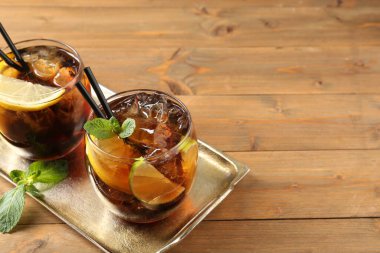 Küba libre kokteylini ahşap masada nane şekeriyle tazeliyorum. Metin için boşluk