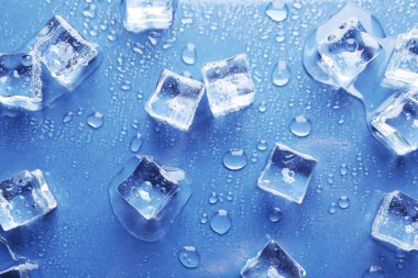 Eriyen buz küpleri ve mavi arkaplanda su damlaları, düz bir zemin