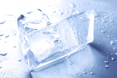 Temiz buz parçaları ve su açık mavi masaya düşer.