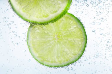 Beyaz arka planda limon dilimli soda, yakın plan.