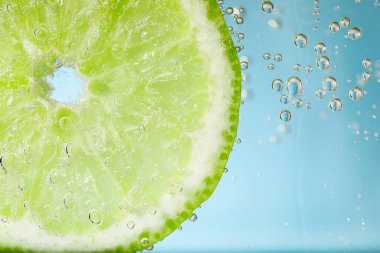 Kireç dilimli soda, açık mavi arkaplan, yakın plan.