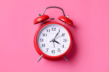 Pembe zemin üzerinde kırmızı alarm saati, üst görünüm