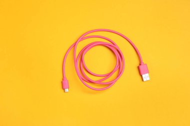 Turuncu arka planda bir USB şarj kablosu, üst görünüm