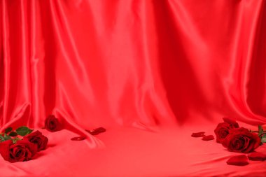 Romantik dekor. Kırışmış kırmızı ipek kumaş üzerinde güzel güller ve taç yaprakları, metin için yer